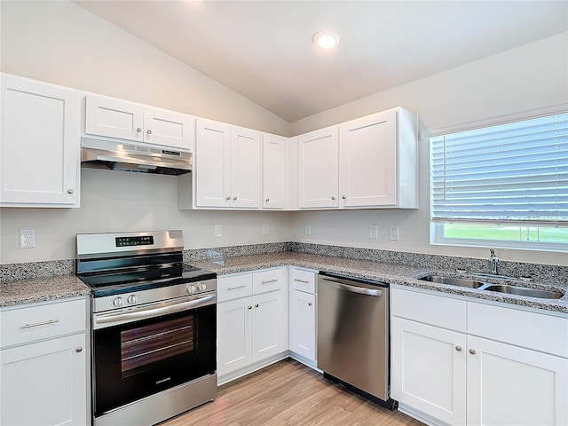 kitchen featuring under cabinet range hood, a sink, lofted ceiling, stainless steel appliances, and white cabinetry