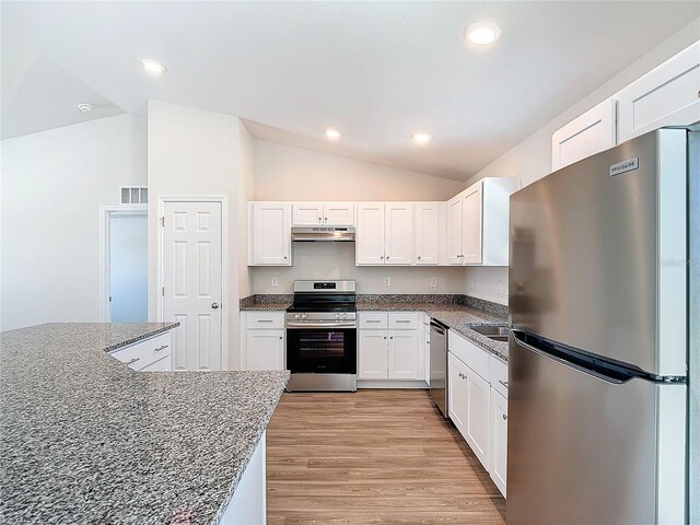 kitchen with vaulted ceiling, appliances with stainless steel finishes, under cabinet range hood, and white cabinetry