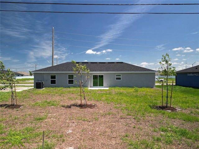 rear view of house featuring cooling unit, a shingled roof, and stucco siding