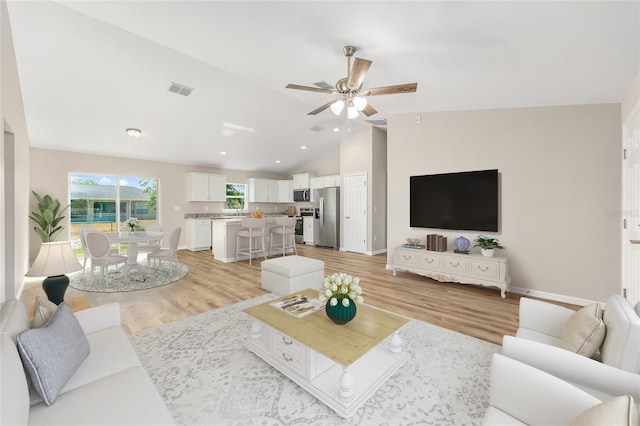 living area with visible vents, lofted ceiling, baseboards, a ceiling fan, and light wood-style flooring