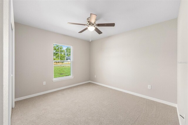empty room featuring carpet floors, ceiling fan, and baseboards