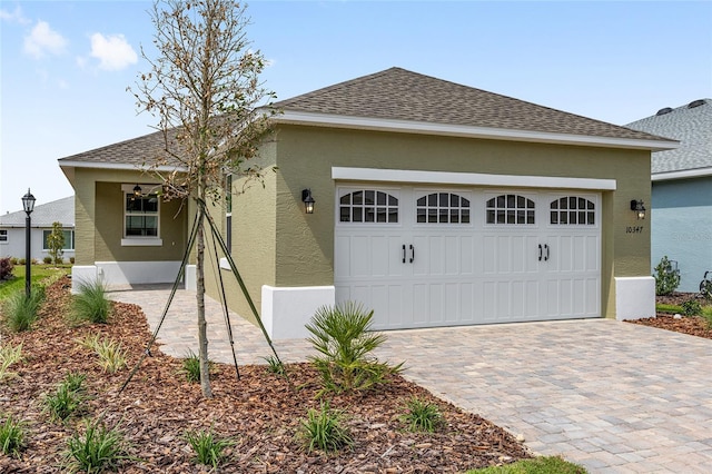 10347 SW 99th Ln, Ocala, FL 34481 - view of front of property featuring stucco siding, an attached garage, decorative driveway, and roof with shingles