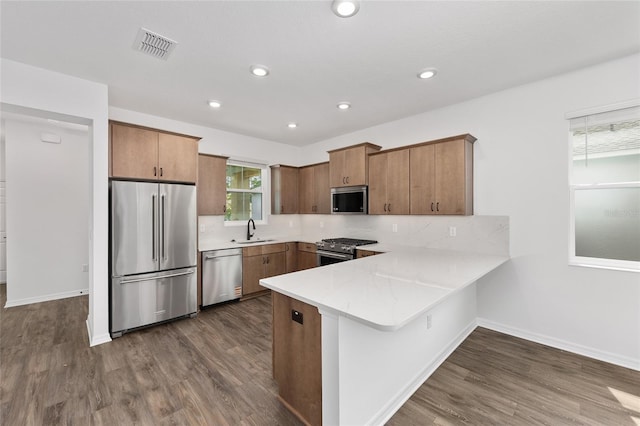 10347 SW 99th Ln, Ocala, FL 34481 - kitchen featuring appliances with stainless steel finishes, a sink, a peninsula, light countertops, and dark wood-style flooring
