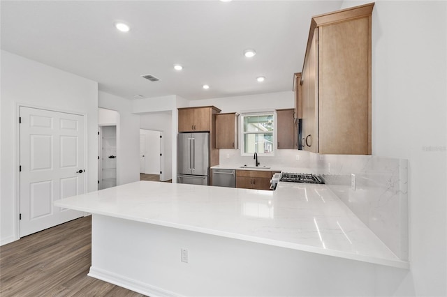 10347 SW 99th Ln, Ocala, FL 34481 - kitchen featuring stainless steel appliances, a sink, a peninsula, wood finished floors, and light countertops