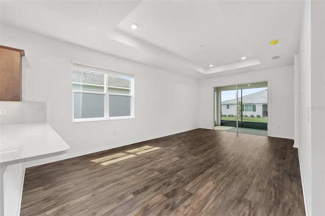 10347 SW 99th Ln, Ocala, FL 34481 - unfurnished living room featuring a raised ceiling, dark wood-style floors, recessed lighting, and baseboards