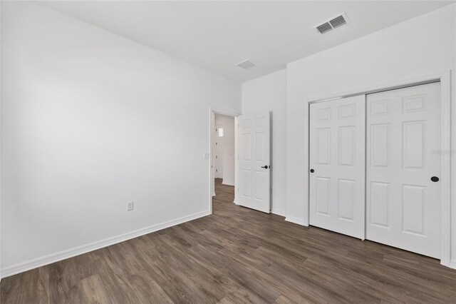 10347 SW 99th Ln, Ocala, FL 34481 - unfurnished bedroom featuring dark wood finished floors, baseboards, and a closet
