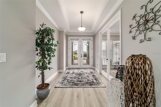 10082 SW 82nd Place Rd, Ocala, FL 34481 - foyer featuring french doors, a raised ceiling, ornamental molding, light wood-style floors, and baseboards