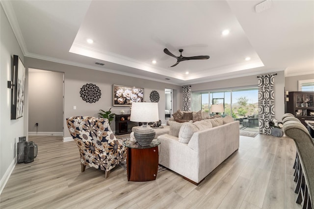 10082 SW 82nd Place Rd, Ocala, FL 34481 - living area featuring a tray ceiling, light wood-style flooring, a ceiling fan, baseboards, and crown molding