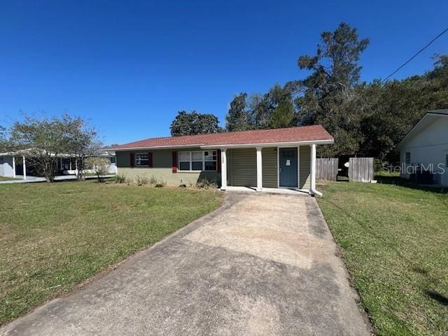 ranch-style house with driveway and a front yard