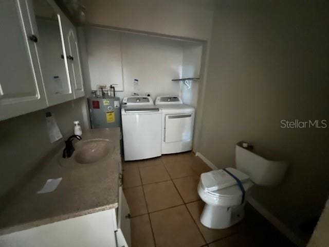 bathroom featuring electric water heater, electric panel, tile patterned floors, toilet, and washer and dryer