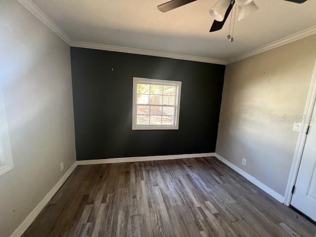spare room featuring baseboards, ceiling fan, ornamental molding, and wood finished floors