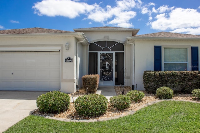 15691 SW 11th Court Rd, Ocala, FL 34473 - property entrance with a garage, stucco siding, and concrete driveway