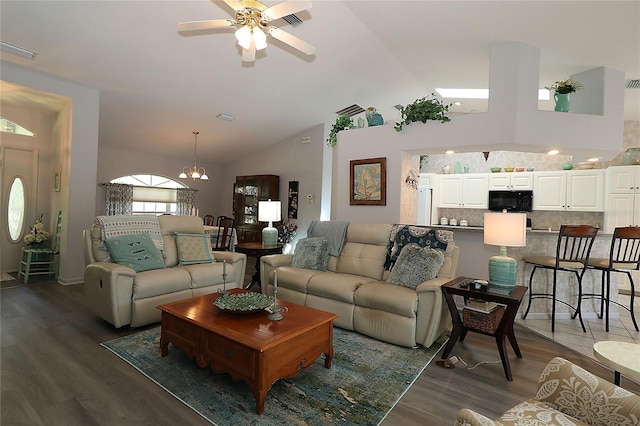 living room with visible vents, high vaulted ceiling, dark wood finished floors, and ceiling fan with notable chandelier