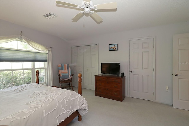 bedroom featuring carpet floors, ceiling fan, visible vents, and a closet