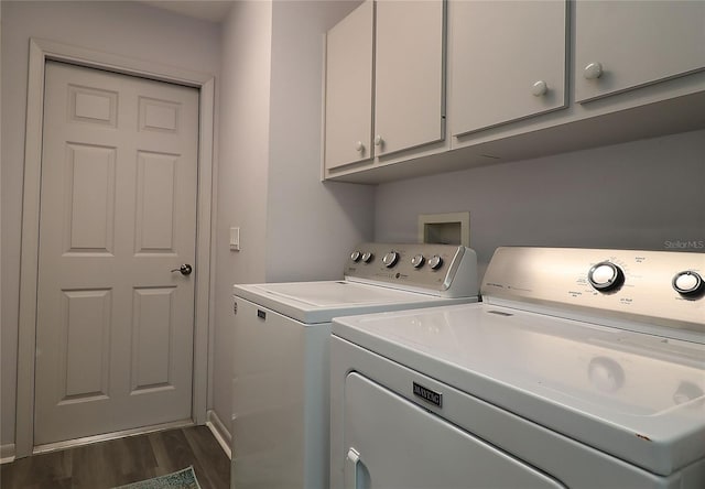 washroom featuring cabinet space, dark wood-style floors, and washing machine and clothes dryer