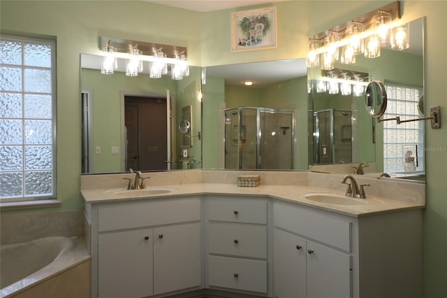 bathroom featuring double vanity, a sink, a garden tub, and a stall shower