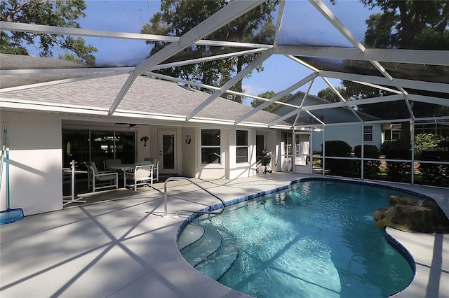 pool featuring a patio, glass enclosure, and ceiling fan