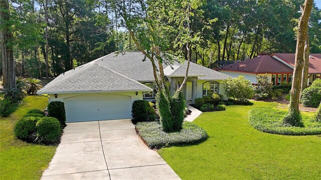 9129 SW 193rd Cir, Dunnellon, FL 34432 - ranch-style home with concrete driveway, a garage, a front lawn, roof with shingles, and stucco siding