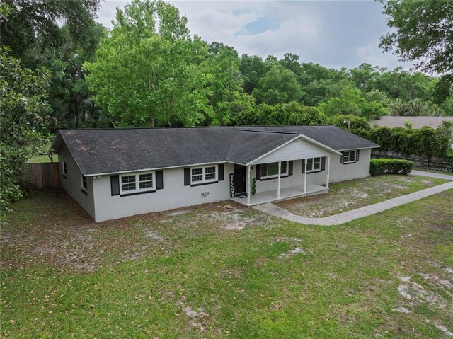 4430 SE 47th Pl, Ocala, FL 34480 - view of front facade with stucco siding, a patio, fence, and a front lawn