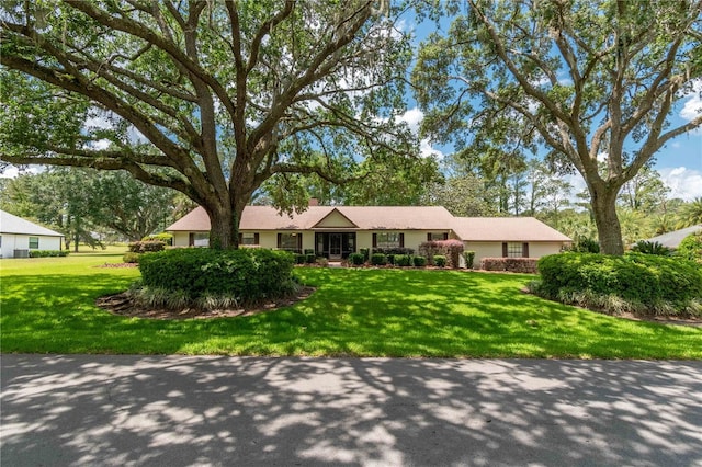 single story home featuring a front lawn