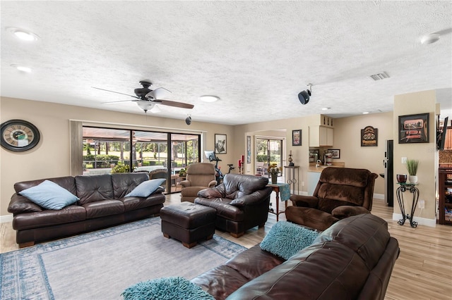 living area with a ceiling fan, baseboards, and light wood-style floors