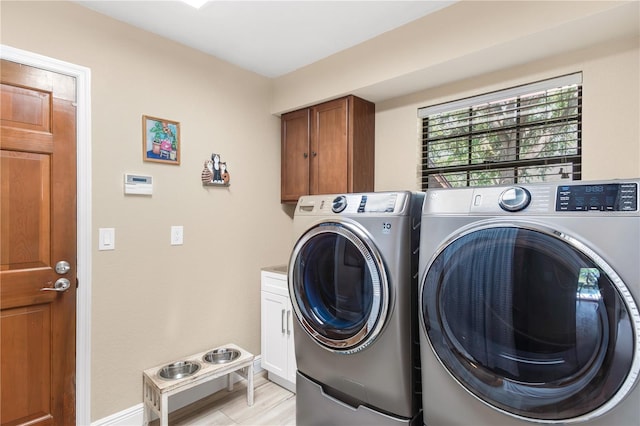 clothes washing area with separate washer and dryer, baseboards, and cabinet space