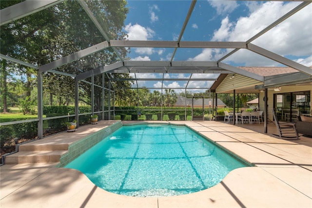 outdoor pool with a patio and glass enclosure