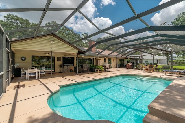 outdoor pool featuring glass enclosure, a patio area, ceiling fan, and outdoor dining space