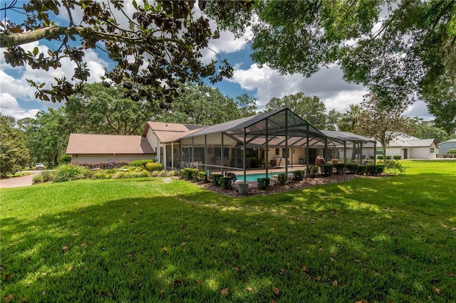 rear view of house with a yard, an outdoor pool, and glass enclosure