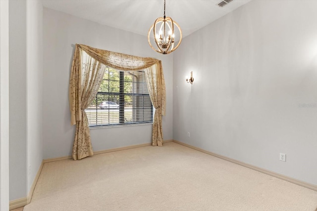 carpeted empty room featuring an inviting chandelier and baseboards