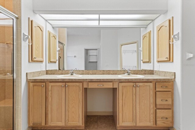 full bathroom with double vanity, a sink, and a stall shower