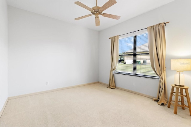 empty room featuring baseboards, light colored carpet, and ceiling fan