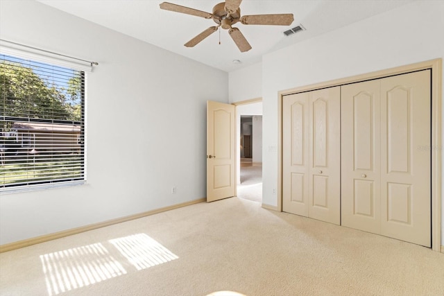 unfurnished bedroom with carpet flooring, a ceiling fan, baseboards, visible vents, and a closet