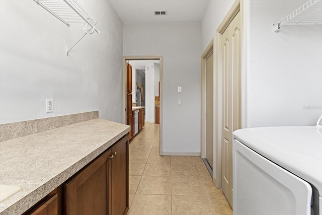 laundry area with laundry area, light tile patterned flooring, and visible vents