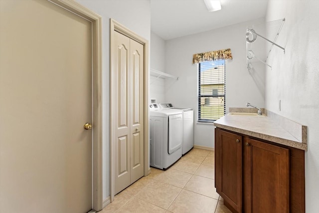 laundry room with light tile patterned floors, laundry area, washer and clothes dryer, and a sink