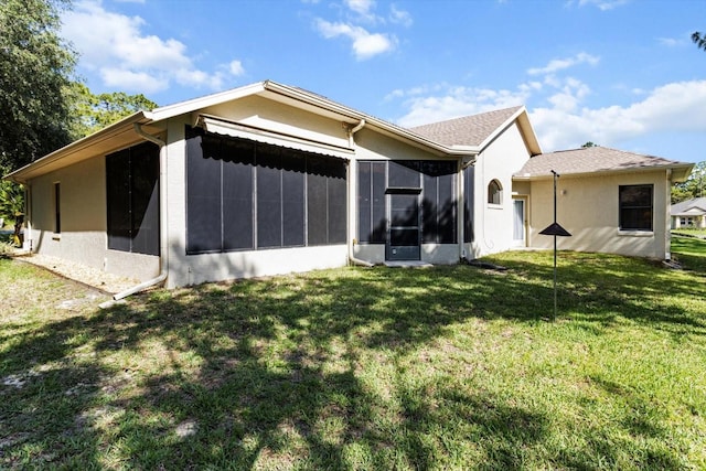 back of house featuring a yard and a sunroom