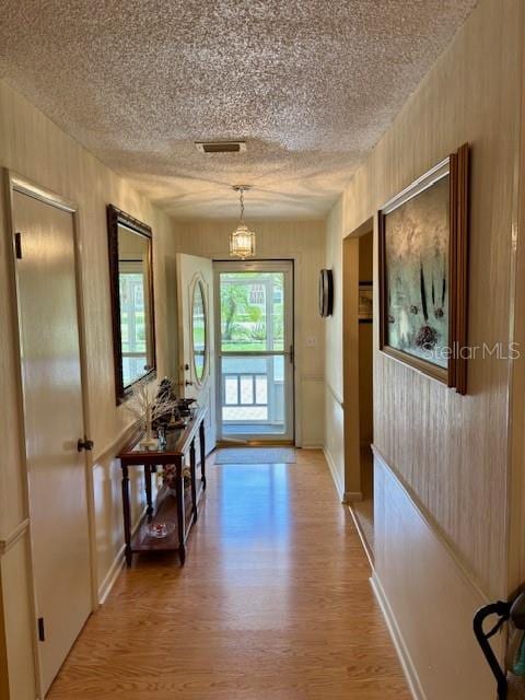 4145 SE 3rd St, Ocala, FL 34471 - doorway featuring baseboards, light wood finished floors, and a textured ceiling