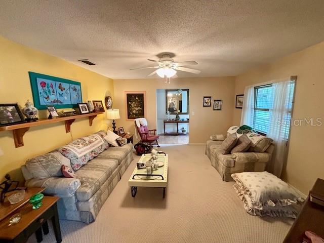 4145 SE 3rd St, Ocala, FL 34471 - carpeted living room featuring visible vents, a textured ceiling, and ceiling fan