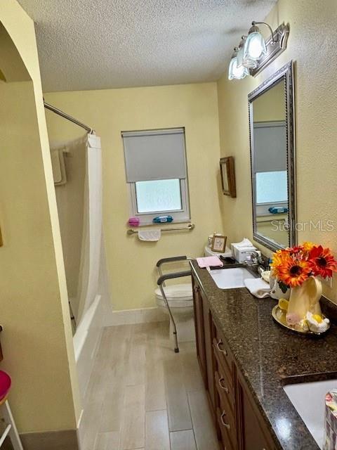 4145 SE 3rd St, Ocala, FL 34471 - full bathroom featuring double vanity, a textured ceiling, a sink, baseboards, and toilet