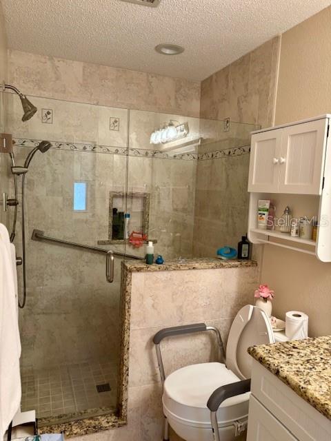4145 SE 3rd St, Ocala, FL 34471 - full bath featuring vanity, a stall shower, toilet, and a textured ceiling