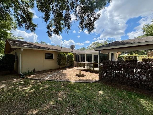 4145 SE 3rd St, Ocala, FL 34471 - rear view of property with a lawn and stucco siding