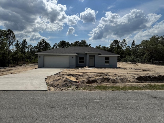 view of front of house with an attached garage, driveway, and stucco siding