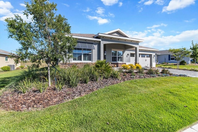 view of front of property featuring a front lawn, stone siding, stucco siding, an attached garage, and driveway