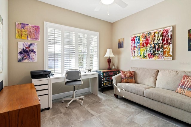 office space featuring a ceiling fan and baseboards