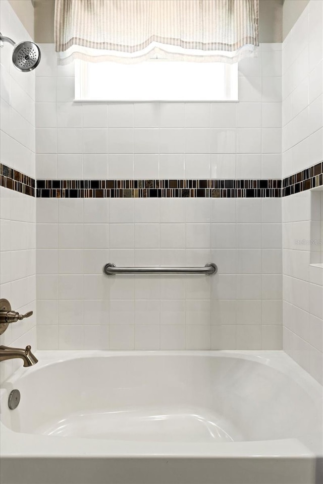 bathroom with washtub / shower combination and plenty of natural light