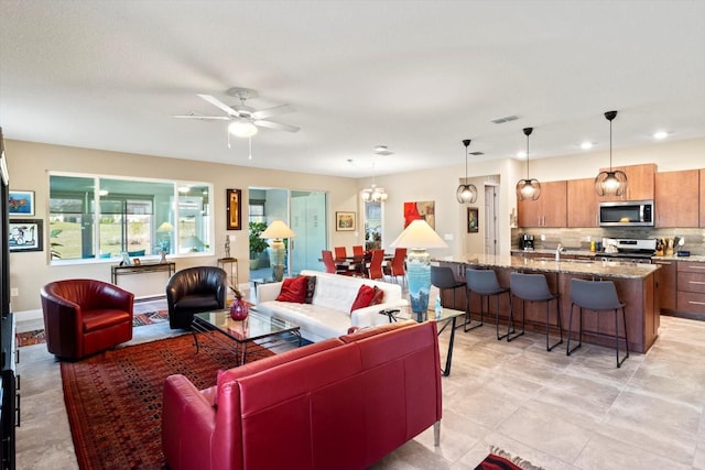 living room featuring ceiling fan with notable chandelier, recessed lighting, and visible vents