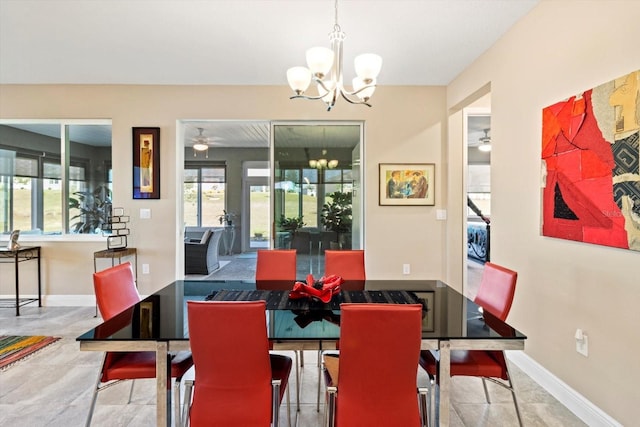 dining area with baseboards and ceiling fan with notable chandelier