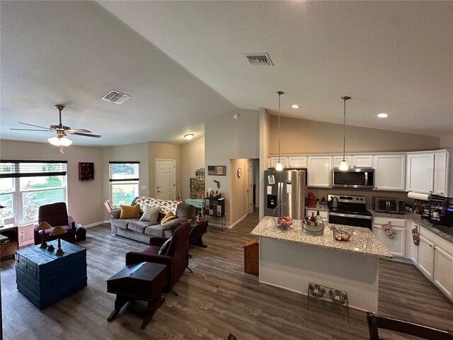 living area with a ceiling fan, lofted ceiling, dark wood finished floors, and visible vents