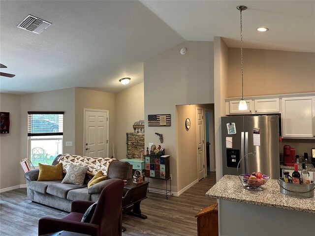 living room with baseboards, visible vents, dark wood-style flooring, and lofted ceiling