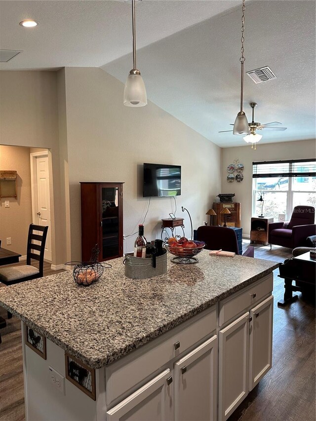kitchen with open floor plan, visible vents, and lofted ceiling
